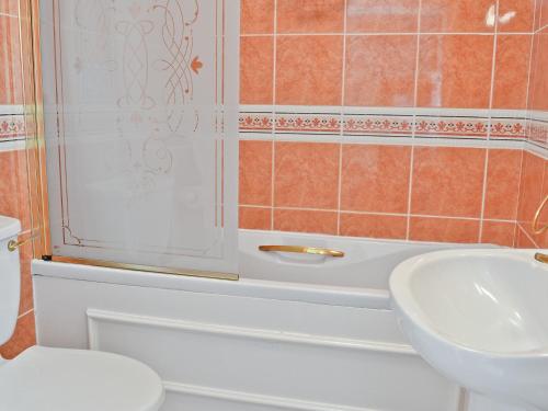 a bathroom with a toilet and a sink at Hope Cottage in Lindale