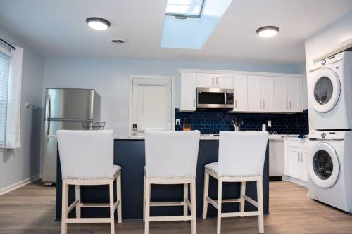 een keuken met witte apparaten en witte krukken bij Beautiful 3-bedroom home off-street parking. in Greensboro