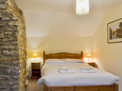 Langton MatraversにあるMulberry Cottage - 27905のベッドルーム1室(ベッド1台、タオル2枚付)