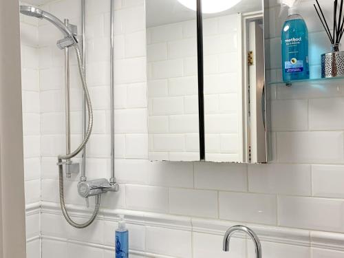 a shower in a bathroom with a mirror at Fishermans Cottage in Plymouth