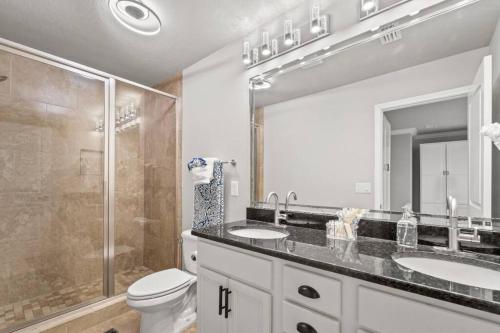 une salle de bain avec deux lavabos et une douche dans l'établissement Emerald Beach Cottage, Walk to the Beach!, à Inlet Beach