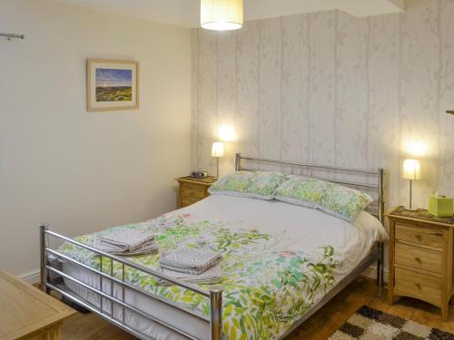 a bedroom with a bed and two night stands at Linnets in Beaminster