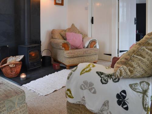 a living room with a couch and a wood stove at Little Whiteleigh in Week Saint Mary