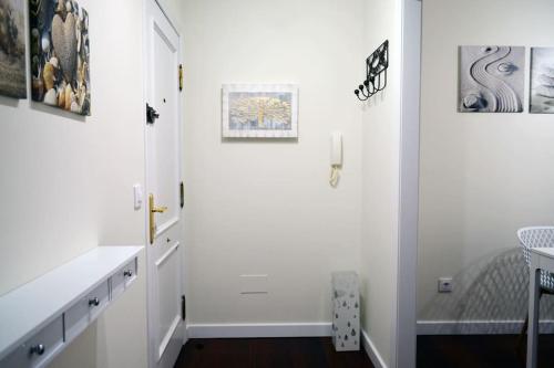 a room with white walls and a hallway with a table at APARTAMENTO BARLOVENTO in San Vicente de la Barquera