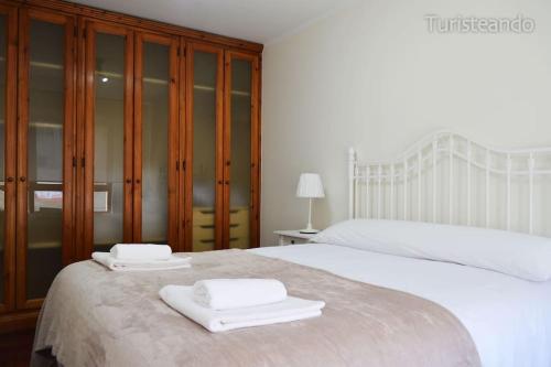 a bedroom with two white towels on a bed at APARTAMENTO BARLOVENTO in San Vicente de la Barquera