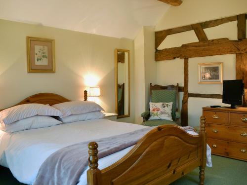ein Schlafzimmer mit einem Bett und eine Kommode mit einem Spiegel in der Unterkunft Howards End in Leysters