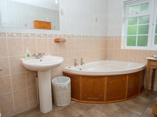 a bathroom with a tub and a sink at Crabtrees in Ringstead