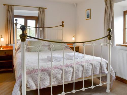 a bedroom with a white bed with a canopy at Hay Loft -23894 in Aylmerton