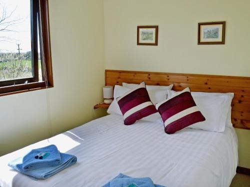 a bedroom with a white bed with towels on it at Finch Lodge - E4793 in Nawton