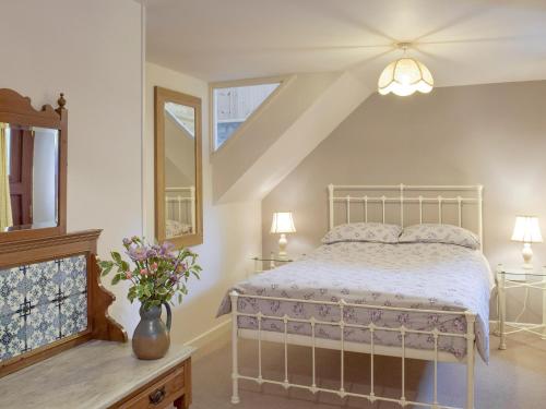 a bedroom with a bed and a vase of flowers at The Stable - Hw7461 in Henrys Moat