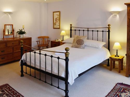 a bedroom with a large bed and two chairs at The Coach House - 24439 in Bodmin