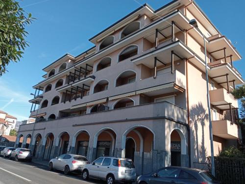 a large white building with cars parked in front of it at Appartamento Aurora in Verbania