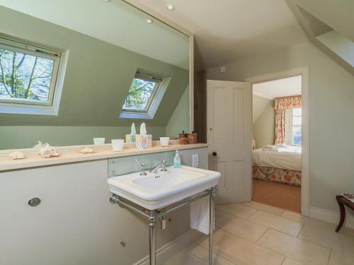 bagno con lavandino e specchio di The Glen Farmhouse a Crocketford