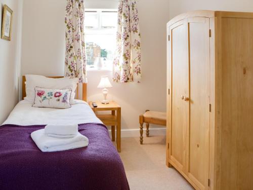ScalbyにあるSpringthorpe Cottageのベッドルーム(紫色のベッド1台、窓付)