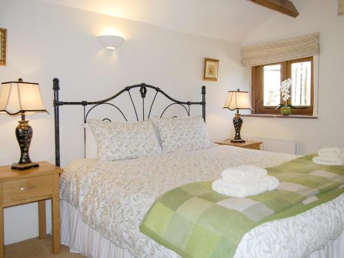 a bedroom with a bed with a green and white comforter at The Garth in Mungrisdale