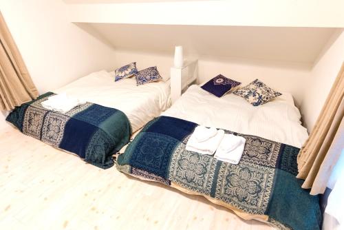 two beds sitting next to each other in a room at Gracias Shibuya - Great Access to Shinjuku & Shibuya in Tokyo
