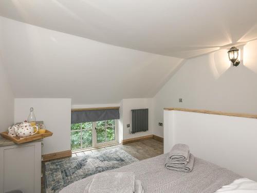 a white bedroom with a bed and a window at The Coach House - Ukc2365 in Watton