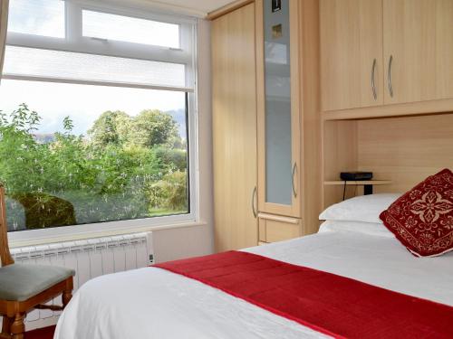 a bedroom with a bed and a large window at Badgers Rake 7 in Ambleside