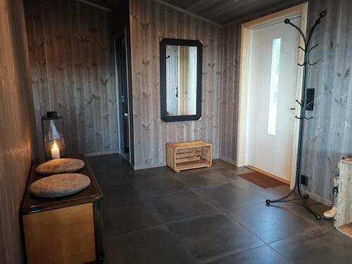 a room with a table with a lamp and a mirror at Flott hytte sentralt i Hallingdal in Ål