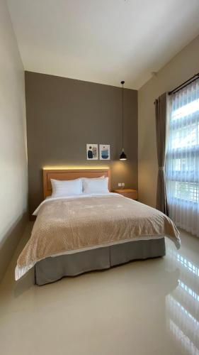 sypialnia z dużym łóżkiem i oknem w obiekcie The Pines Smart Homes w mieście Batu