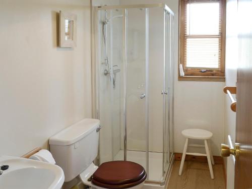 a bathroom with a shower and a toilet and a sink at Lochinchard Cottages in Kinlochbervie