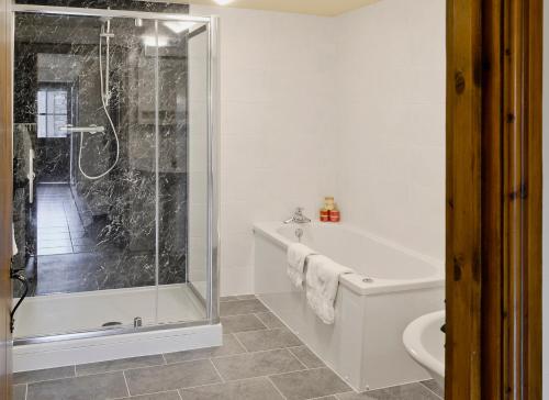 a bathroom with a shower and a tub and a toilet at The Byre - Ifw in Airton