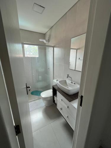 a bathroom with a toilet and a sink and a shower at Casa com Piscina in Florianópolis