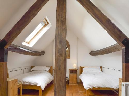 2 camas en un ático con vigas de madera en South View Cottage, en Chadlington