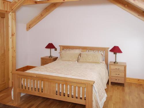 LlanarthにあるThe Farmhouseのベッドルーム1室(木製ベッド1台、ナイトスタンド2台付)