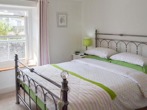 1 dormitorio con 2 camas y ventana en Lavender Cottage, en Buckfastleigh