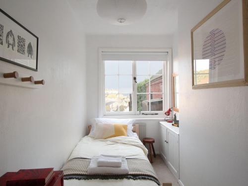 a small bedroom with a bed and a window at Seagulls Nest in Hastings