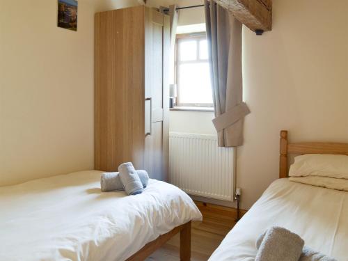 a small room with two beds and a window at Blackbird Cottage - 25116 in Flamborough