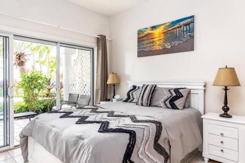 a white bedroom with a bed and a window at Shore to Please - Large Studio Condo in Turtle Cove