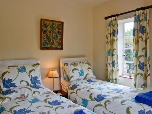 a bedroom with two beds and a window at The Old Post Office in Eaton Bishop