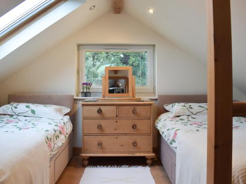 a bedroom with two beds and a mirror on a dresser at The Boiler House in Osmotherley