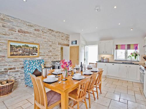 a kitchen and dining room with a wooden table and chairs at The Mill House-tt3 in Warleggan