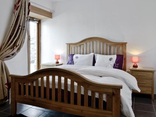 ein Schlafzimmer mit einem Holzbett mit zwei Nachttischen und zwei Lampen in der Unterkunft What A Beauty - Thr in Tresmeer