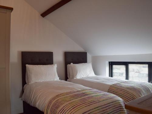 two beds sitting next to each other in a bedroom at Derbys Loft in Beccles