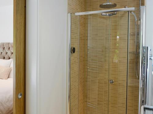 a shower with a glass door in a bedroom at Hidden Gem in Berrynarbor