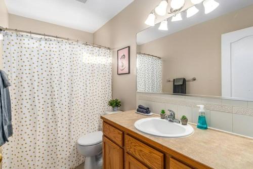 a bathroom with a sink and a toilet and a mirror at Spacious home, gameroom, 9mi GEG, 5mi downtown, 5mi to hospitals, close to all universities in Spokane Valley