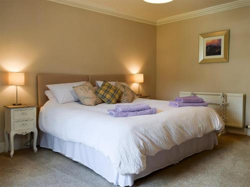 a bedroom with a large white bed with pillows at Toadhall in Aberfeldy