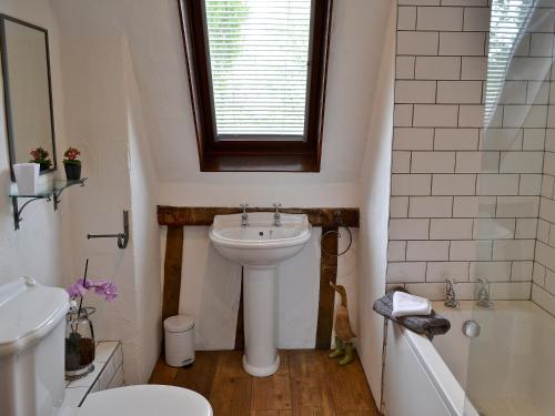 uma casa de banho com um lavatório, um WC e uma banheira em The Old Stables em Rickinghall