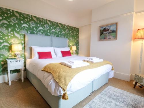 1 dormitorio con 1 cama grande con almohadas rojas en Collett House, en Southwold