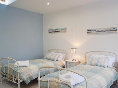 サンダースフットにあるSouthlands Barnの白い壁の客室で、ツインベッド2台が備わります。