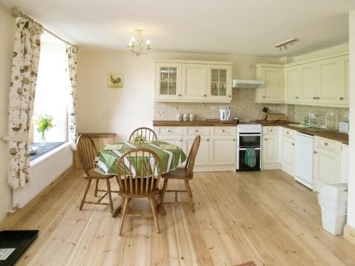 una cocina con mesa y sillas. en Peartree Cottage, en St Mellion