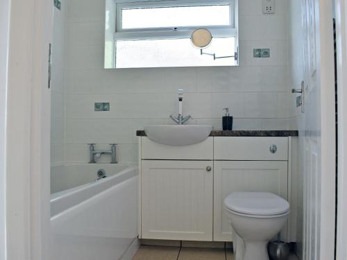a white bathroom with a sink and a toilet at Moles Leap in Brading