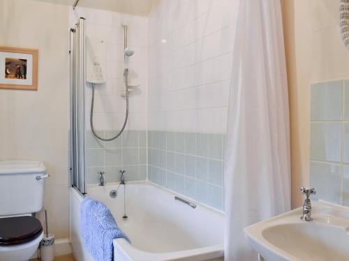 a bathroom with a tub and a toilet and a sink at Old Inzievar in Blairhall