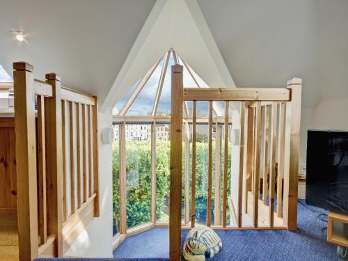 a room with a staircase with a large window at Garden Cottage in Linlithgow