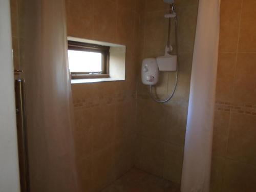 a bathroom with a shower and a window at Whipple Tree Cottage in Cratfield