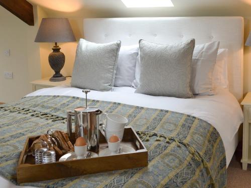 a bed with a tray of food on it at Bell Cottage in Gristhorpe